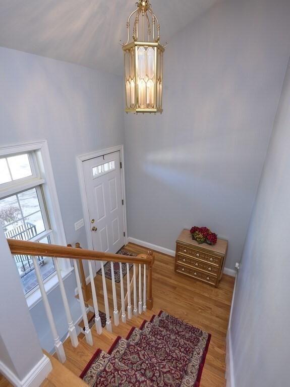 entrance foyer featuring an inviting chandelier, baseboards, and wood finished floors