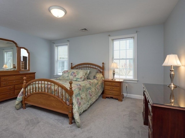 bedroom with baseboards, visible vents, and light colored carpet