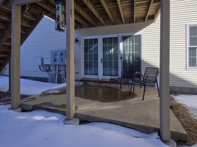 snow covered patio featuring french doors