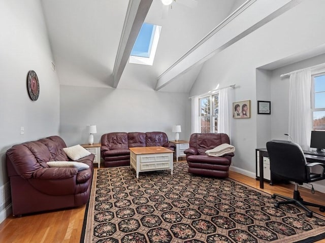 living room featuring a skylight, high vaulted ceiling, a wealth of natural light, and wood finished floors