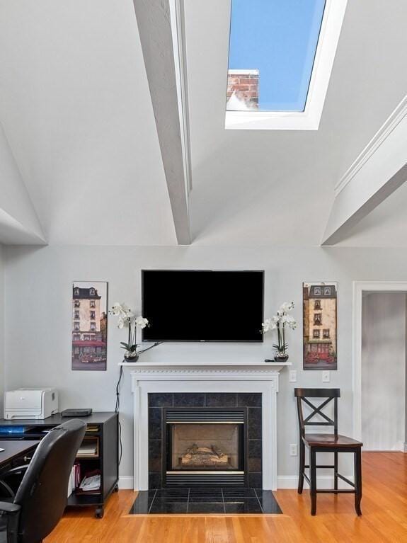 living room with lofted ceiling, wood finished floors, and a tile fireplace