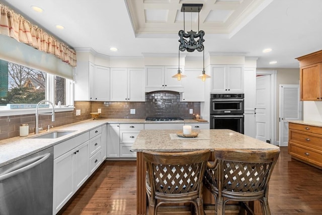 kitchen featuring white cabinetry, sink, stainless steel dishwasher, and decorative light fixtures