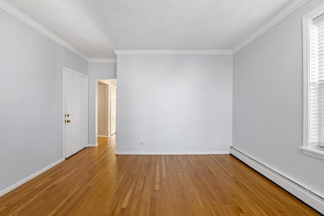 spare room featuring ornamental molding, light hardwood / wood-style flooring, a wealth of natural light, and a baseboard heating unit