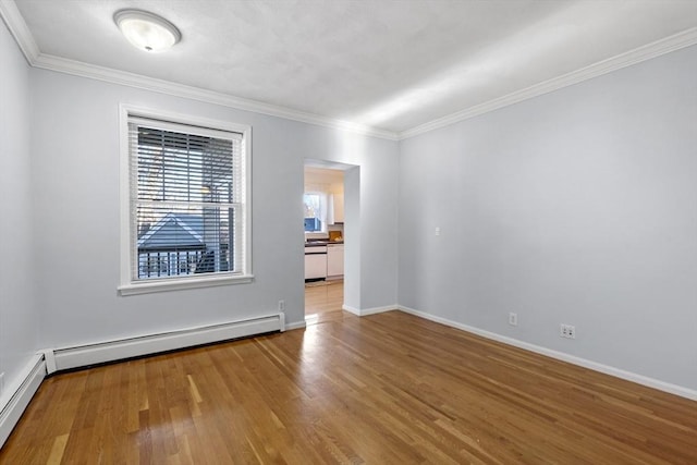 spare room featuring wood-type flooring, baseboard heating, and ornamental molding