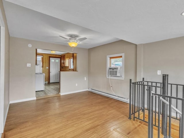 unfurnished room featuring baseboards, ceiling fan, a baseboard heating unit, cooling unit, and light wood-style flooring