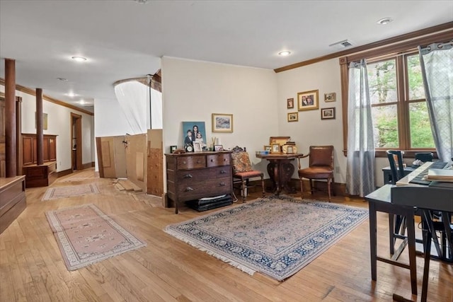 sitting room with light wood-type flooring, crown molding, and recessed lighting
