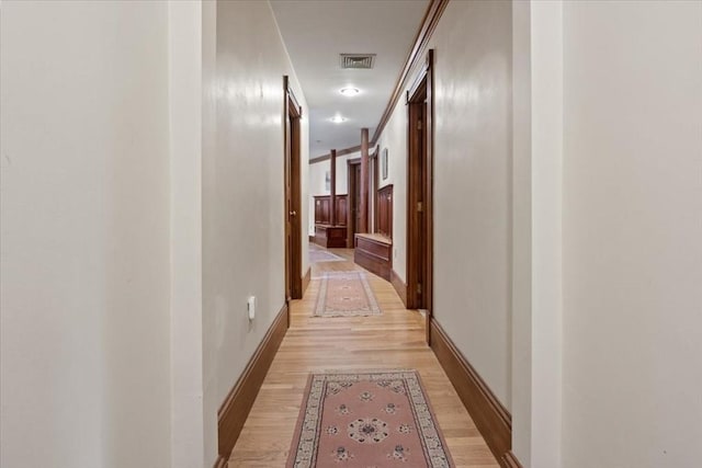 corridor with light wood finished floors and baseboards