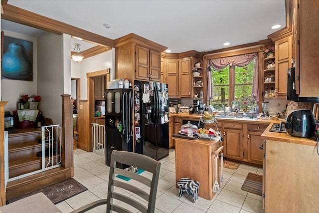kitchen featuring open shelves, black fridge with ice dispenser, light tile patterned floors, a center island, and butcher block counters