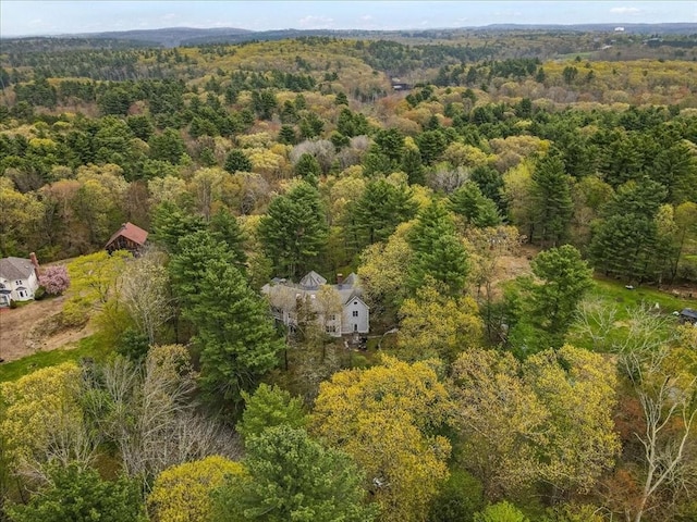 aerial view of property and surrounding area with a heavily wooded area