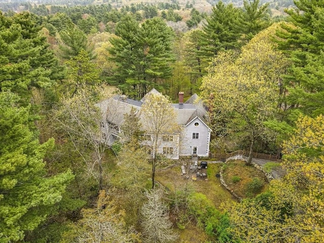 aerial view of property and surrounding area featuring a heavily wooded area