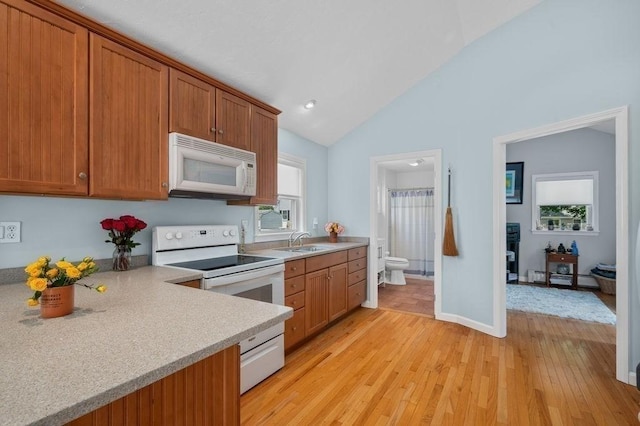 11 Beaver Park, Danvers, MA 01923 - kitchen with white appliances, light wood-type flooring, light countertops, brown cabinets, and a baseboard heating unit