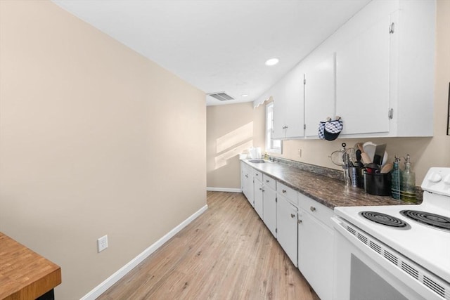 kitchen with sink, white electric range oven, light wood-type flooring, and white cabinets