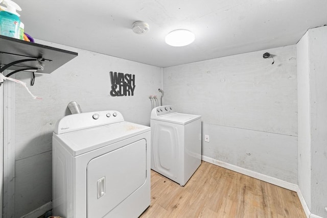 clothes washing area featuring washer and dryer and light wood-type flooring