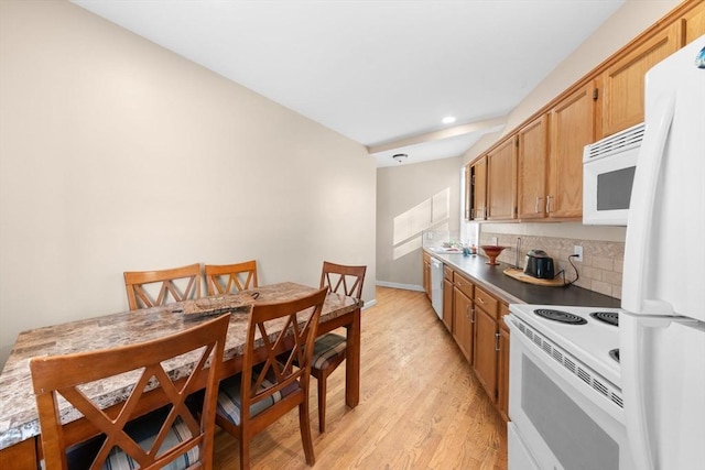 kitchen featuring white appliances and light hardwood / wood-style flooring