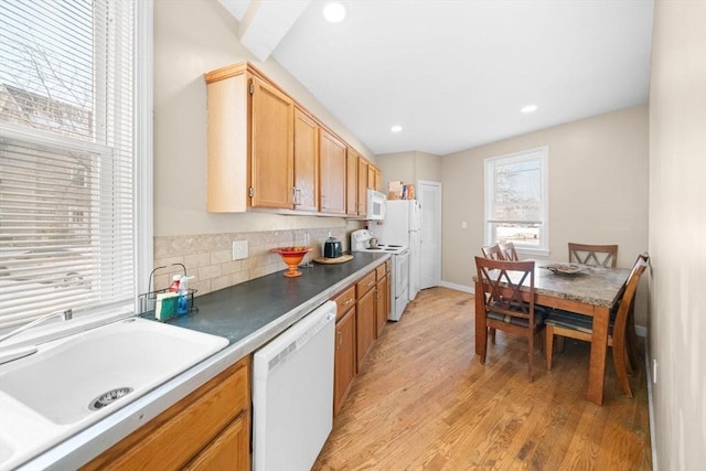 kitchen featuring sink, white appliances, tasteful backsplash, light brown cabinetry, and light wood-type flooring