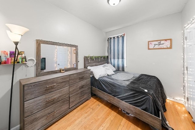 bedroom with vaulted ceiling and light hardwood / wood-style floors