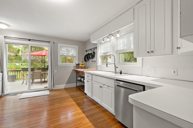 61 Fiske Ave, Waltham, MA 02453 - kitchen with stainless steel dishwasher, light wood-style flooring, light countertops, and white cabinets