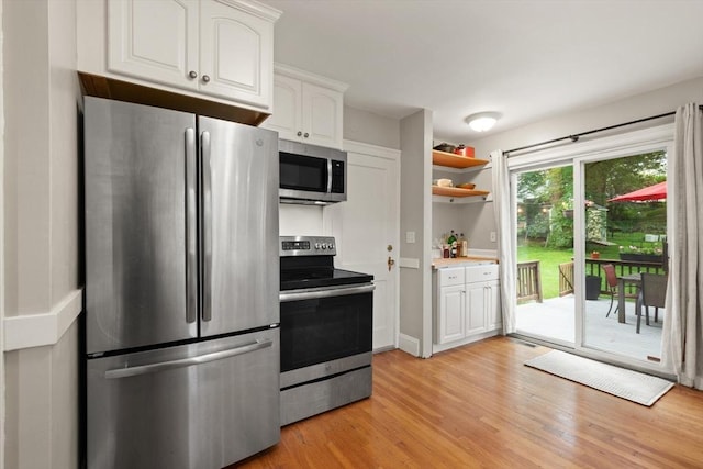 61 Fiske Ave, Waltham, MA 02453 - kitchen with stainless steel appliances, white cabinets, light wood-type flooring, light countertops, and open shelves