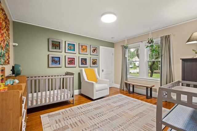 61 Fiske Ave, Waltham, MA 02453 - bedroom with ornamental molding, wood finished floors, and a crib