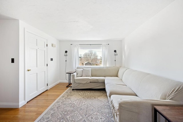 living room featuring baseboards and light wood finished floors