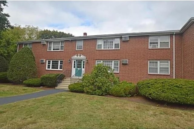 view of front of house featuring brick siding and a front lawn