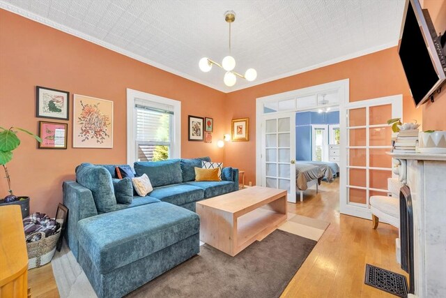 17 Teel St Unit 1, Arlington, MA 02474 - living room with french doors, crown molding, wood finished floors, and a chandelier