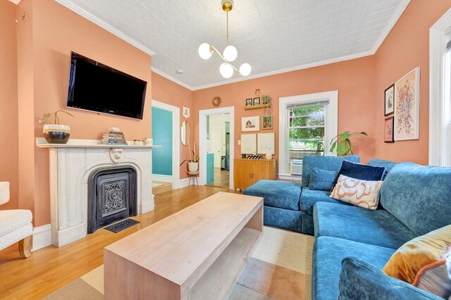 17 Teel St Unit 1, Arlington, MA 02474 - living room with ornamental molding, light wood-style flooring, a chandelier, and a fireplace with flush hearth