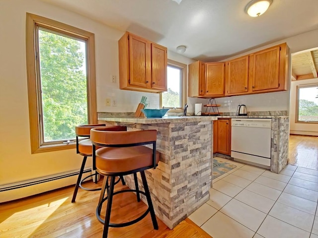 30 Norris Path, Falmouth, MA 02536 - kitchen with dishwasher, a baseboard radiator, a peninsula, a kitchen bar, and light countertops