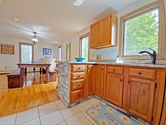30 Norris Path, Falmouth, MA 02536 - kitchen featuring a sink, baseboard heating, light tile patterned floors, a peninsula, and backsplash