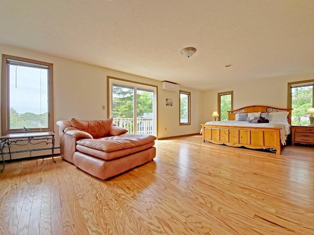 30 Norris Path, Falmouth, MA 02536 - bedroom featuring a baseboard heating unit, access to exterior, wood finished floors, and a wall unit AC
