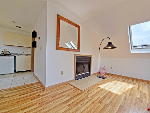 30 Norris Path, Falmouth, MA 02536 - unfurnished living room with a fireplace, light wood-type flooring, vaulted ceiling, and baseboards