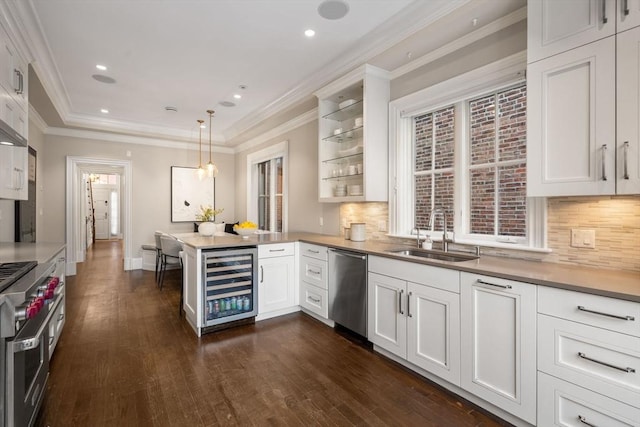 kitchen featuring white cabinets, sink, beverage cooler, and decorative light fixtures