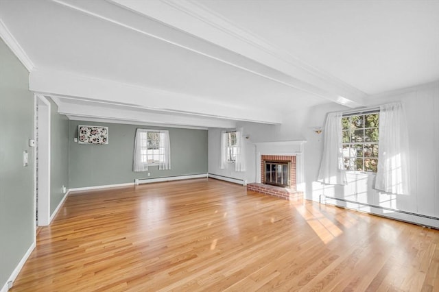 unfurnished living room with beam ceiling, a brick fireplace, a baseboard heating unit, and a healthy amount of sunlight