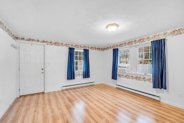 spare room featuring cooling unit, a baseboard radiator, and light hardwood / wood-style floors