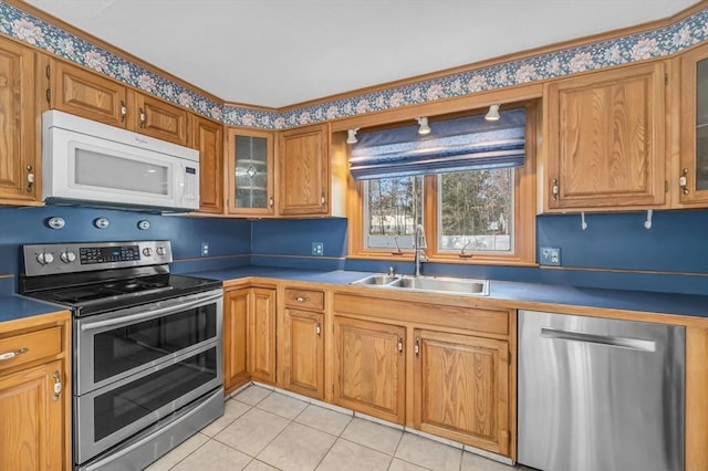 kitchen with sink, light tile patterned floors, and appliances with stainless steel finishes