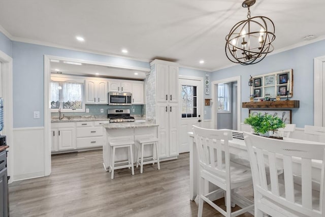 kitchen featuring appliances with stainless steel finishes, white cabinets, and crown molding