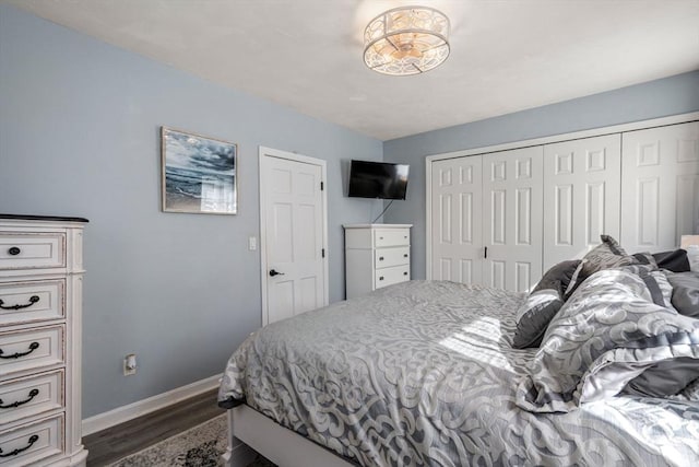 bedroom with a closet, dark wood-style flooring, and baseboards