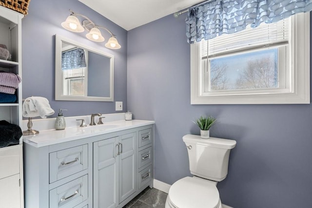 bathroom with vanity, toilet, and baseboards