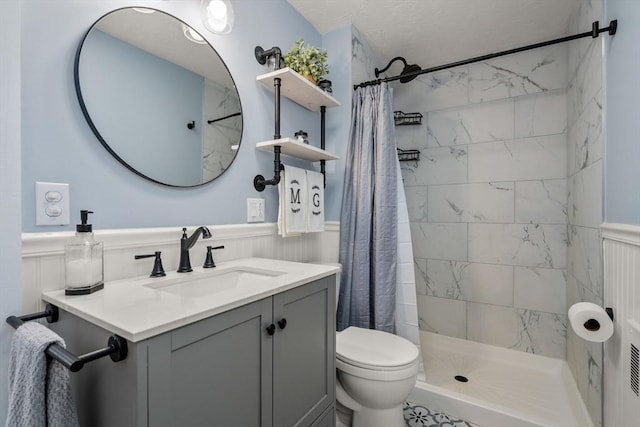 bathroom featuring a wainscoted wall, a tile shower, and toilet