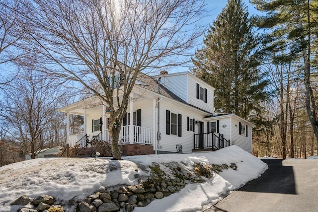 view of snowy exterior featuring a porch