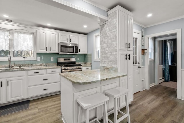 kitchen featuring stainless steel appliances, light wood-type flooring, white cabinetry, and a sink