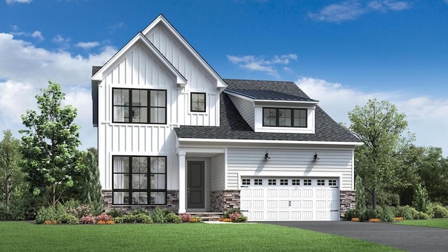 modern farmhouse style home with stone siding, driveway, board and batten siding, and a front yard