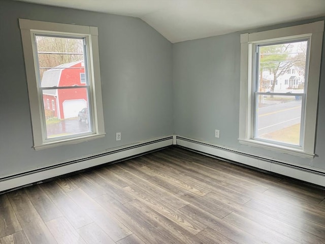 bonus room featuring baseboard heating, light wood-type flooring, and vaulted ceiling