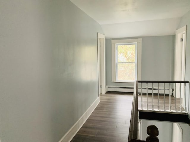 corridor featuring lofted ceiling, baseboard heating, and dark hardwood / wood-style flooring