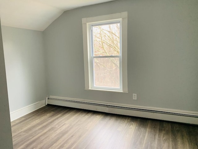 bonus room featuring a baseboard heating unit, vaulted ceiling, and light hardwood / wood-style flooring