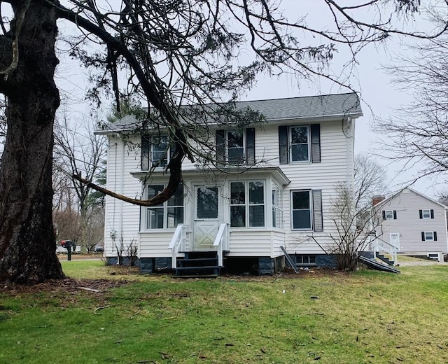 rear view of property featuring a lawn