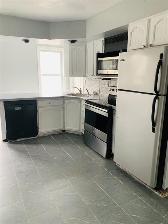 kitchen with white cabinets, appliances with stainless steel finishes, and sink