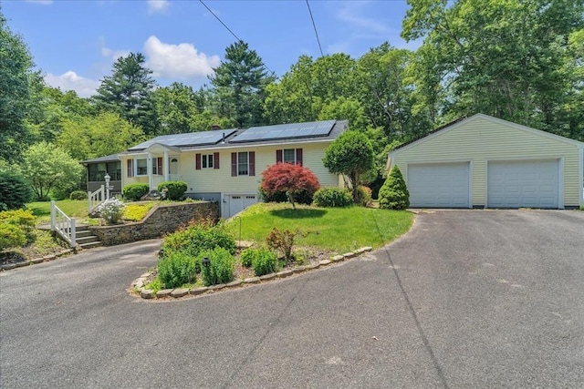33 Dean St, Norton, MA 02766 - split foyer home with roof mounted solar panels, a detached garage, a front yard, and a sunroom