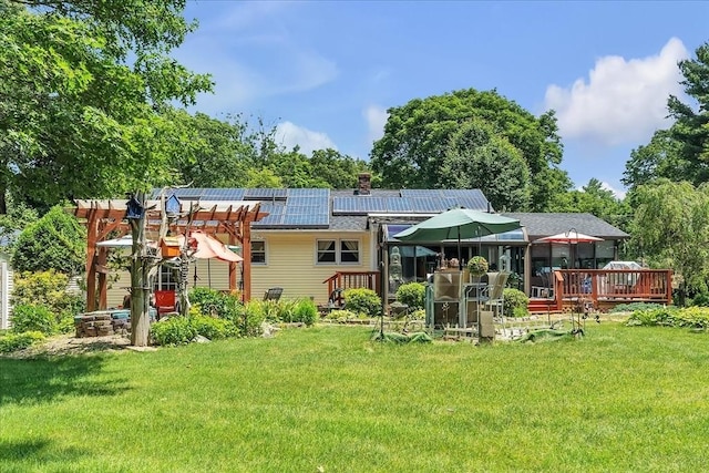 33 Dean St, Norton, MA 02766 - rear view of house with a wooden deck, solar panels, a chimney, and a lawn