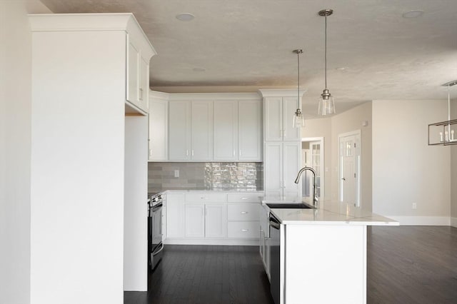 kitchen with an island with sink, white cabinetry, hanging light fixtures, and sink